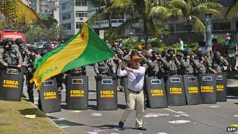 A man waves a flag as security forces guard the site of the Libra auction on 21 October 2013
