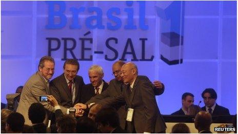 Brazil's Mines and Energy Minister Edison Lobao (second left), with representatives of the winning consortium