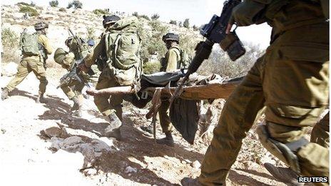 Israeli troops carry Mohammad Assi on stretcher (22/10/13)