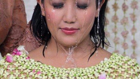 Princess Hayu, 29, covered with a cape of flowers is bathed with water during a purification ritual as part of the royal wedding ceremony