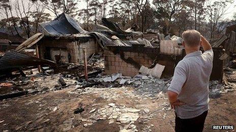 man surveys damage to his house