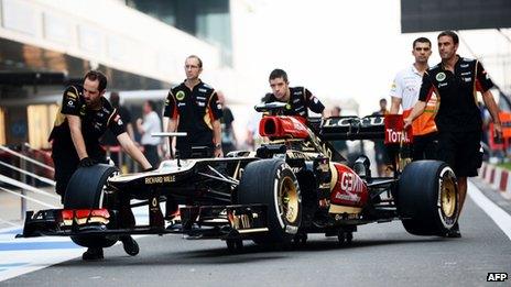 Lotus F1 team crew members push the race car used by French driver Romain Grosjean at the Buddh International circuit on 24 Oct 24, 2013