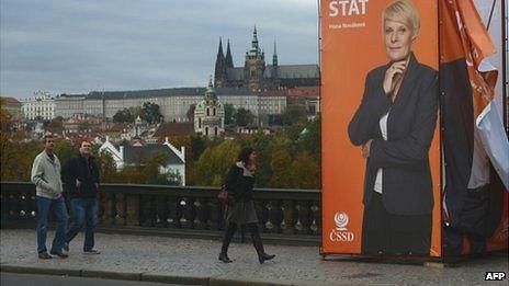 People walk past an election campaign banner of The Czech Social Democrats party (CSSD) on October 17, 2013 in front of the Prague castle in Prague.