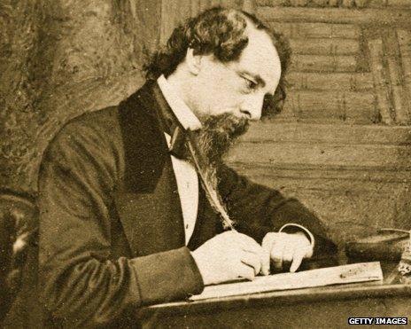 Charles Dickens writing at desk