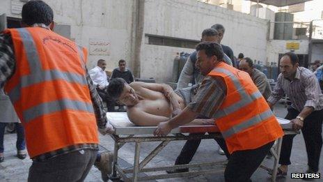 Emergency crews help a car bomb victim in Damascus province in this handout photo provided to Reuters by Syrian state news agency SANA