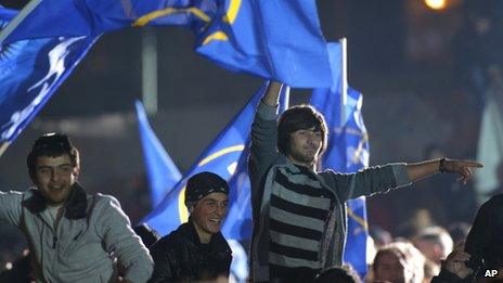 People react and wave flags during a pre-election concert to support presidential candidate from the ruling Georgian Dream coalition, Georgy Margvelashvili, in Tbilisi, Georgia,
