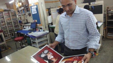 Dhiraj Kacker looking at a wedding album he has published
