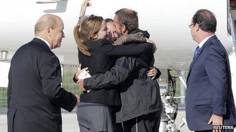 Former French hostage Daniel Larribe is welcomed by relatives as President Francois Hollande (far right) and Defence Minister Jean-Yves Le Drian look on