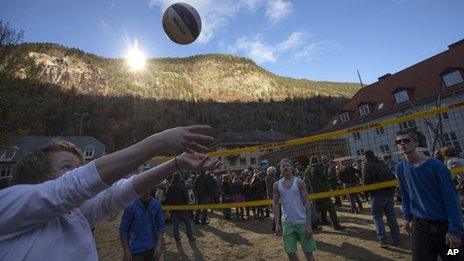Teenagers play beach volleyball at the official opening of the mirrors in Rjukan