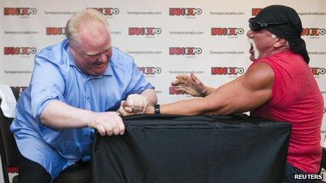 Toronto Mayor Rob Ford (L) arm wrestles former professional wrestler Hulk Hogan to mark the beginning of the Fan Expo in Toronto 23 August 2013
