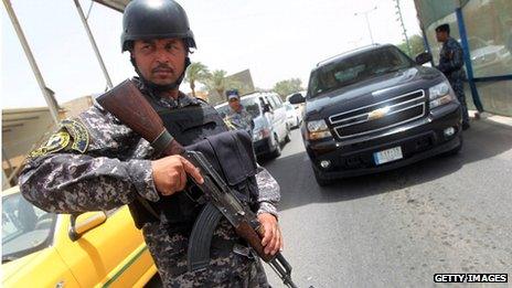 An Iraqi police officer, holding a weapon