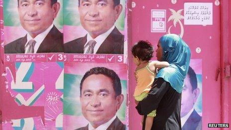 A Maldivian woman looks at posters of Maldivian presidential candidate Abdullah Yameen ahead of their presidential election in Male, 7 November 2013