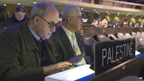The Palestinian Ambassador to UNESCO Elias Sanbar, left, checks his tablet during a session of the UNESCO General Conference, in Paris, Friday 8 November 2013