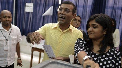 Maldivian Democratic Party (MDP) presidential candidate Mohamed Nasheed, middle, casts his vote at a polling station during the presidential elections on 9 November 2013.
