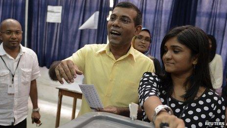 Maldivian Democratic Party (MDP) presidential candidate Mohamed Nasheed, centre, casts his vote at a polling station during the presidential elections on 9 November 2013.
