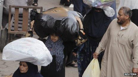Women carry clothes bought at al-Ataba, a popular market in downtown Cairo November 11, 2013