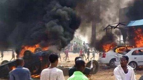 Cars burn in front of a building during protests over fuel subsidy cuts in Khartoum, Sudan - 25 September 2013
