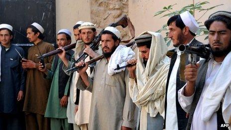 Taliban fighters carry their weapons prior to handing them over at a government peace and reconciliation ceremony in Jalalabad, capital of Nangarhar province on 27 October 2013.