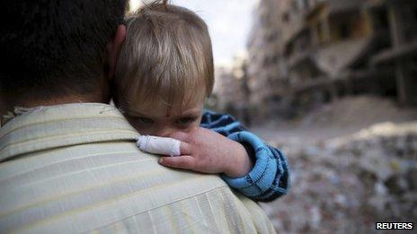 A man holds a child that he said survived shelling from forces loyal to President Bashar al-Assad, in Duma neighbourhood in Damascus, 17 November