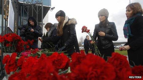 People lay flowers near the fence of Kazan airport