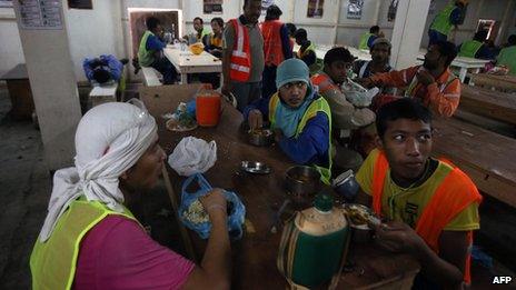 Migrant labourers have a lunch break as they work on a construction site on October 3, 2013 in Doha in Qatar