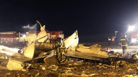 Fire fighters and rescuers work at the crash site