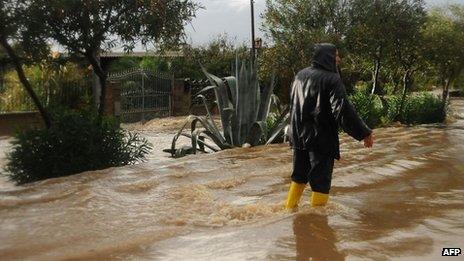 A man walks in a flooded street in Uras, central Sardinia