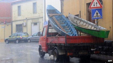 Boats are carried in a truck to give assistance to floods victims in Terralba, central Sardinia