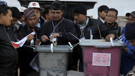 A Nepalese election worker seals a ballot box after poling closed in Kathmandu on 19 November 2013