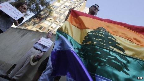 Human rights activists hold up a rainbow flag during an anti-homophobia rally in Beirut in April 2013