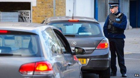 A PCSO speaks to a driver near flats in Brixton, south London, as police are conducting house-to-house inquires in Brixton