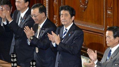 Japanese PM Shinzo Abe (second from right) claps with lawmakers from his Liberal Democratic Party after the secrecy law was approved in parliament's lower house