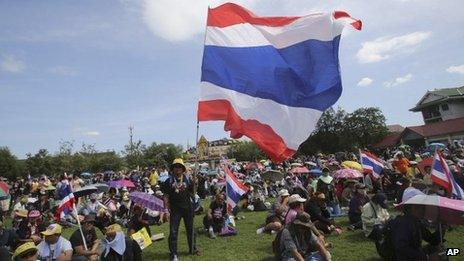 Anti-government protesters with Thai national flags sit at the Royal Thai Army compound in Bangkok, Thailand, 29 November 2013