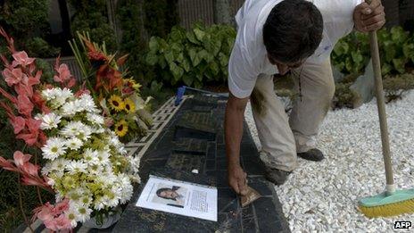 A man cleans the tomb of Colombian drug lord Pablo Escobar on 29 November, 2013 at Montesacro cemetery in Medellin