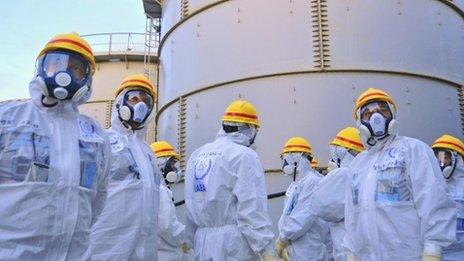 A team of International Atomic Energy Agency (IAEA) experts check out water storage tanks at Fukushima