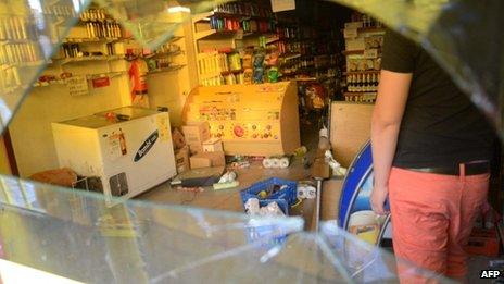 A worker cleans a looted a supermarket on 3 December 2013 in Cordoba