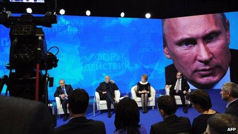 Russia's President Vladimir Putin is seen on a huge screen during a meeting with the All-Russia Popular Front at the Academy of State Service in Moscow on 5 December 2013