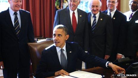 President Obama, surrounded by officials