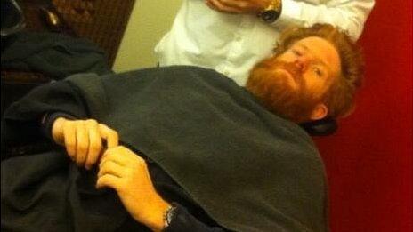 Sean Conway has his beard shaved off