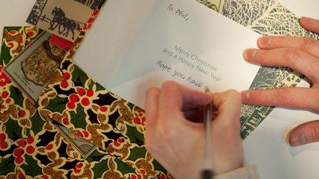Person writes in Christmas card
