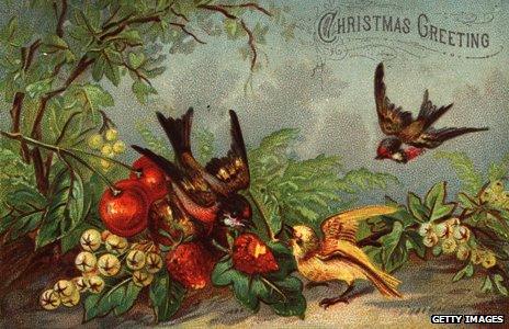 Robins picking strawberries from a bush in this Christmas card from 1880