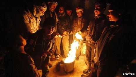 Syrian refugees gather around a fire in the Beqaa Valley. Photo: 12 December 2013