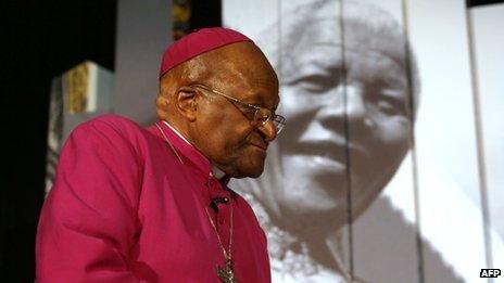 Archbishop Tut before an image of Nelson Mandela