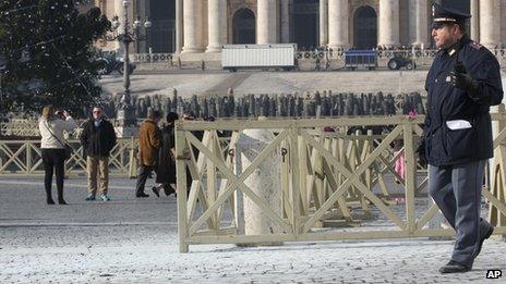 Policeman walks on white powder left from the fire extinguisher in St Peter's Square (19 December 2013)