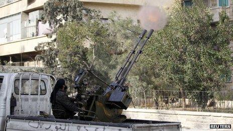 Syrian jihadist rebel from the al-Nusra Front fires an anti-aircraft weapon in Aleppo (18 December 2013)