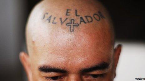 A man with a tattoo on his forehead reading "El Salvador"