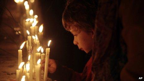 A boy lights a candle marking the events that launched 17 years of military rule in Santiago, Chile. September 2013