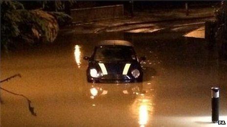 A Mini is caught in flooding in Mallards Way, Maidstone, Kent