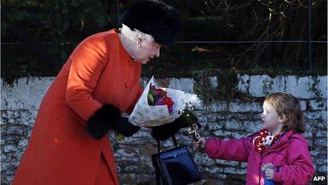 The Queen receives a bunch of flowers from a child after the service