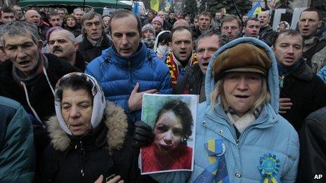 Activists hold the photo of journalist and activist Tetyana Chornovol as they rally outside the Ukrainian Interior Ministry in Kiev on 25 December, 2013